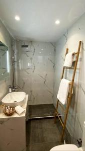 La salle de bains est pourvue d'une douche, d'un lavabo et de toilettes. dans l'établissement Sea Through Apartment Anavissos, à Anavyssos
