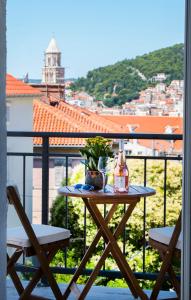 einen Tisch mit einer Flasche Wein und eine Pflanze auf dem Balkon in der Unterkunft Luxury Apartments Bella - Split Centre w Free Parking in Split