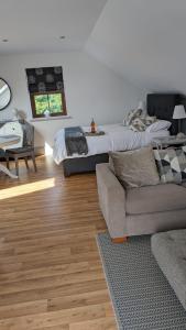 a living room with a bed and a couch at Brodleys' Hill Studio 286d in Ballymena