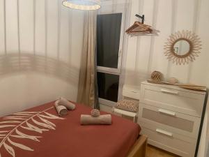 een slaapkamer met een bed, een dressoir en een spiegel bij Appartement TETHYS in Sète
