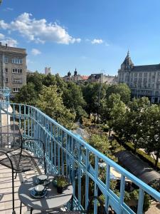 a table and chairs on a balcony with a view of a city at Visit Debrecen 3 Apartman in Debrecen