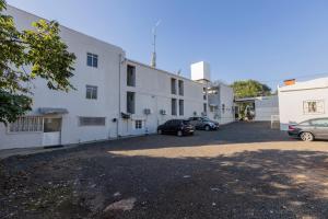伊瓜蘇的住宿－A1 hotel，白色的建筑,有汽车停在停车场