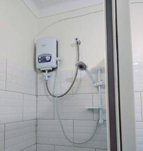 a shower in a bathroom with a shower head at Muggiez Olive, Kira in Kampala