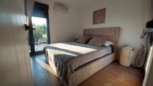 1 dormitorio con cama y ventana grande en Kuća za odmor Eol en Šmrika