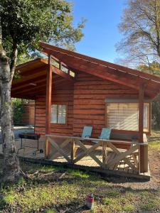 a log cabin with two chairs in front of it at cabañas anvi pucon in Pucón