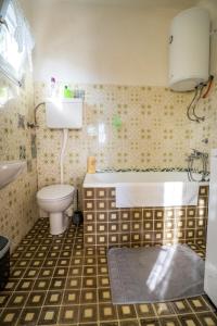 een badkamer met een bad, een toilet en een wastafel bij Apartman Stipe in Brod Moravice