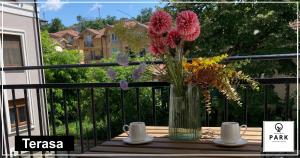 a vase of flowers sitting on a table on a balcony at Apartman Park Promenada in Vrnjačka Banja