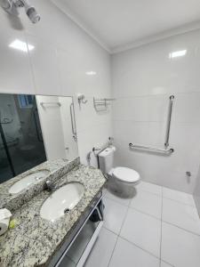 uma casa de banho com um lavatório e um WC em Spazzio diRoma - Apartamentos JN em Caldas Novas