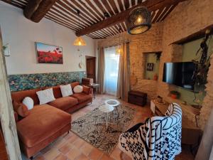 een woonkamer met een bank en een tv bij Provence Now in Cabrières-dʼAvignon