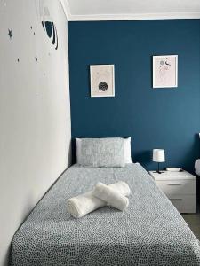 1 dormitorio con 1 cama con pared azul en Apto Familiar Balcones a la Muralla, en Córdoba