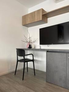 escritorio con silla y TV en la pared en 7 SKY UDINE, en Udine