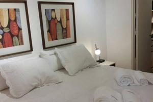 1 dormitorio con 1 cama blanca y 2 cuadros en la pared en Spacious and Modern Apartment in Palermo en Buenos Aires