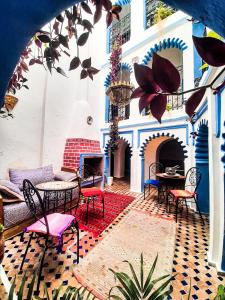 une terrasse avec des tables et des chaises ainsi qu'une cheminée dans l'établissement Riad Said Chaouen, à Chefchaouen