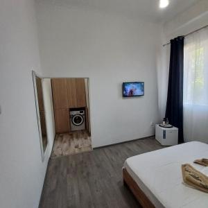 a bedroom with a bed and a door with a microwave at Gradina de Vara Sulina in Sulina