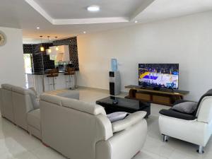 sala de estar con sofás y TV de pantalla plana. en Swiss Luxury Apartments en Ndola