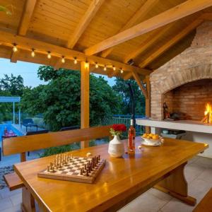 a wooden table in a pavilion with a fireplace at NINA ROSE boutique villa in Lovran