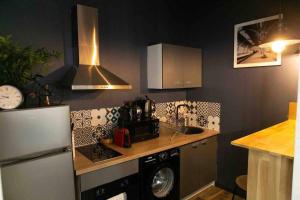 a kitchen with a refrigerator and a counter with a sink at Loft de Courcaille - Balneo - Free Parking - WIFI in Orléans