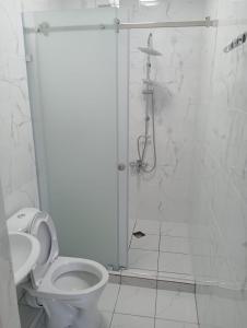 a white bathroom with a shower and a toilet at Keruen Deluxe in Taraz