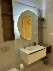 a bathroom with a sink and a mirror at Visit Debrecen 3 Apartman in Debrecen +69 photos