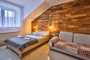 ウニエユフにあるApart-House Uniejówの木製の壁のベッドルーム1室(ベッド2台付)