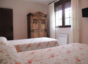 1 dormitorio con 2 camas y armario de madera en Apartamentos Artigot, en Gea de Albarracín