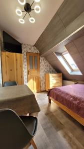 sypialnia z łóżkiem i wentylatorem sufitowym w obiekcie Pańska Izba w Chałupach