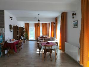 comedor con mesas y sillas y sala de estar en Conacul Doamnei Nucșoara, en Nucşoara