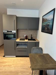 a kitchen with stainless steel appliances and a wooden table at Coeur vieille ville in Annecy