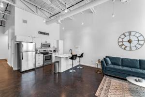 a living room with a blue couch and a kitchen at Deep Ellum Art Novea in Dallas