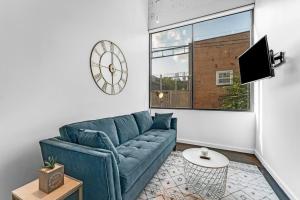 a living room with a blue couch and a clock at Deep Ellum Art Novea in Dallas