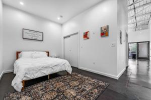 a white bedroom with a bed and a rug at Deep Ellum Art Novea in Dallas
