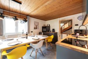 a kitchen with a large island with yellow chairs at Chalet Stanzertal in Strengen