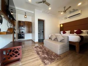 a bedroom with a bed and a couch and a kitchen at GRB RESORT in Tiruchchendūr