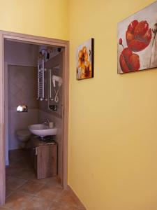 een badkamer met een wastafel en een schilderij aan de muur bij Borgo Gaggi in Gaggi