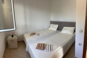 two beds in a small room with white walls at Villy Apartments Dobra Voda in Bar