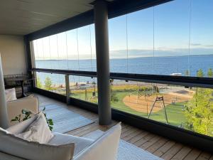 a room with a balcony with a view of the ocean at Top, cozy, lakeside, sauna and free indoor parking in Tampere