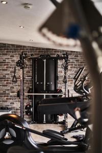 een fitnessruimte met een bakstenen muur en cardio-apparatuur bij Hotel Hoeri am Bodensee in Gaienhofen