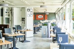 un ristorante con tavoli in legno e sedie blu di Hotel Hoeri am Bodensee a Gaienhofen