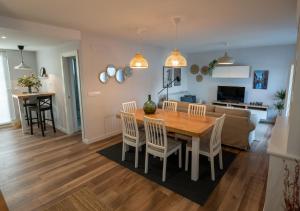 卢安科Casa Manolo的配有木桌椅的厨房和客厅