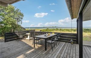 una terraza de madera con mesa y sillas. en Cozy Home In Fllenslev With House Sea View, en Føllenslev