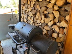 a grill against a wall with a pile of wood at Chata na Zbojskej in Pohronská Polhora