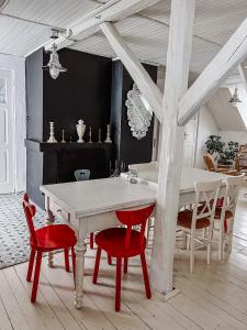 a dining room with a white table and red chairs at Górna79 in Jugowice