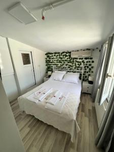 a bedroom with a white bed with a green wall at Heybeliada Pansiyon in Istanbul