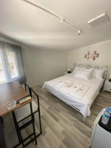 a bedroom with a white bed and a table at Heybeliada Pansiyon in Istanbul