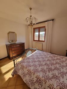 a bedroom with a bed and a dresser and a television at Casa Bortoli in Castiglione della Pescaia