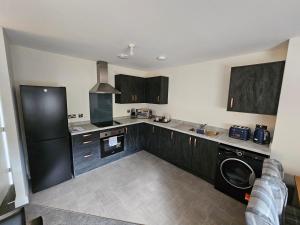 a kitchen with a black refrigerator and a dishwasher at Oakmere Apartments in Chinley