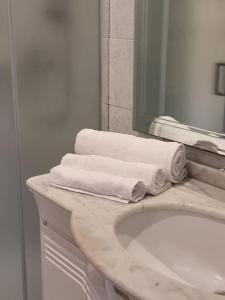 a bathroom with a sink and a mirror and towels at Casa Bortoli in Castiglione della Pescaia