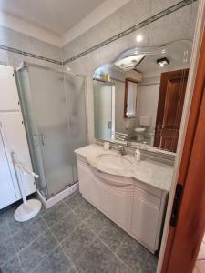 a bathroom with a sink and a shower and a mirror at Casa Bortoli in Castiglione della Pescaia