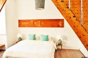 a bedroom with a bed with white sheets and blue pillows at Feeling Chiado 15 in Lisbon