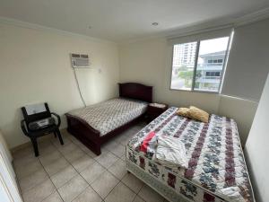 1 dormitorio con 2 camas y ventana en Departamento en chipipe salinas, en Salinas